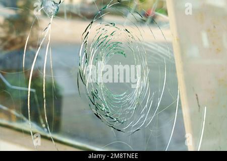 Broken shattered glass with circles of cracks close up Stock Photo