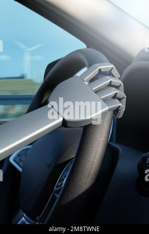 Robot arm on a steering wheel. Artificial intelligence drives a car. Autonomous vehicle concept. Stock Photo
