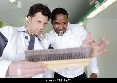 apprentice learning how to paint with a thick brush Stock Photo