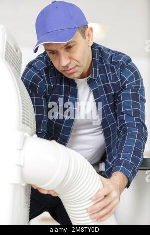 builder installer of ventilation with tools in hands Stock Photo