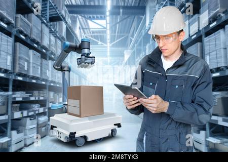 Warehouse manager with digital tablet controls robot and drone Stock Photo