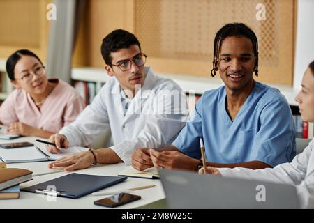 Diverse group of young medical professionals in discussion during meeting or seminar Stock Photo