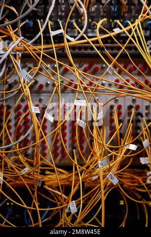Vertical background image of server cabinet with yellow internet cables and wires connected to ports, copy space Stock Photo