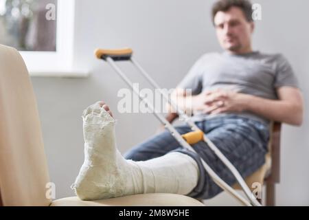Close up of a young man's Plaster leg cast and after a running injury or fall Stock Photo