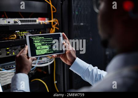 Closeup of network engineer using tablet while setting up servers, copy space Stock Photo