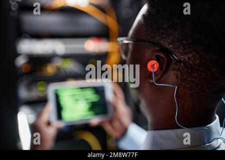 Close up of network technician wearing ear protection while working in server room, copy space Stock Photo
