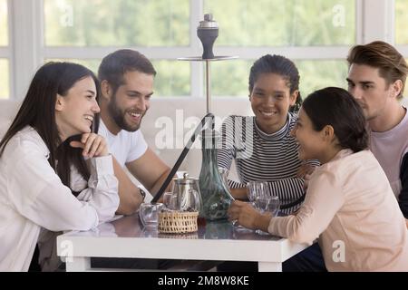 Multiracial group of happy cheerful young friends smoking hookah Stock Photo