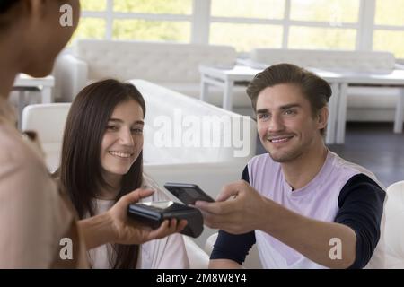 Happy young handsome man paying for lunch in cafe Stock Photo