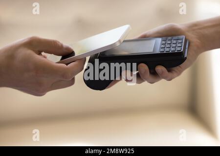 Contactless payment POS terminal and smartphone in human hands Stock Photo