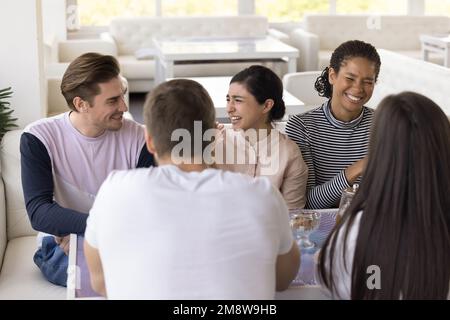 Diverse group of cheerful friends meeting in cafe Stock Photo