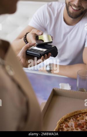 Cheerful customer paying bill by banking app on mobile phone Stock Photo