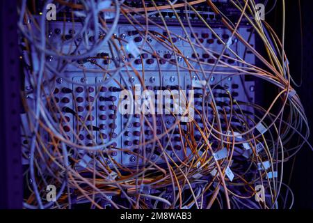 Close up background image of server cabinet with cables and wires in purple neon light, copy space Stock Photo