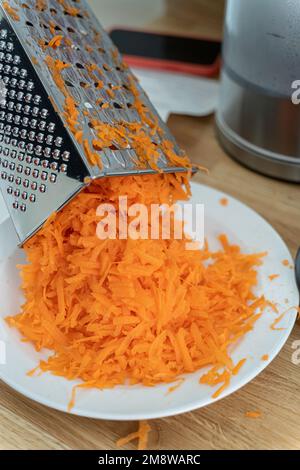 https://l450v.alamy.com/450v/2m8warc/chef-preparing-food-using-a-grating-kitchen-utensil-to-grate-a-carrot-2m8warc.jpg