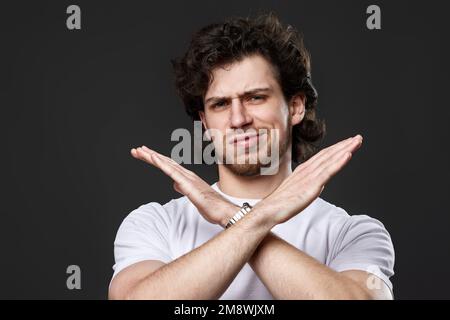 young upset bearded man showing stop gesture Stock Photo