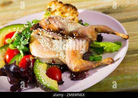 tobacco salad Quail-tobacco with sesame and salad of avocado is tasty dish Stock Photo
