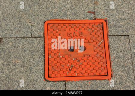 Manhole cover of the gas pipeline system. A massive metal hatch for access to city communications in the pavement. Stock Photo