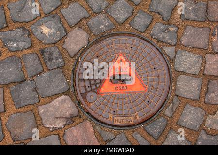 Manhole cover of the gas pipeline system. A massive metal hatch for access to city communications in the pavement. Stock Photo