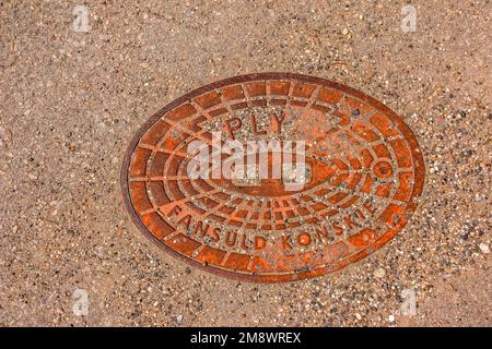 Manhole cover of the gas pipeline system. A massive metal hatch for access to city communications in the pavement. Stock Photo