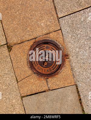 Manhole cover of the gas pipeline system. A massive metal hatch for access to city communications in the pavement. Stock Photo