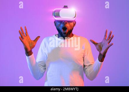 Shocked african american guy with VR headset gesturing Stock Photo