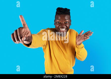 Gotcha. Cheerful Young Black Male Poiting At Camera With Finger Stock Photo