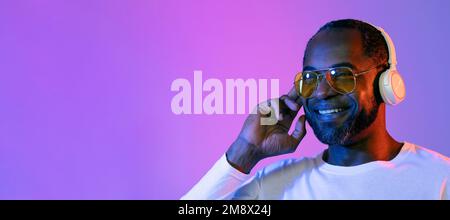 Happy mature handsome black man using headphones Stock Photo