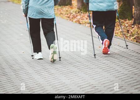 Nordic walking in autumn, senior women exercising outdoors Stock Photo