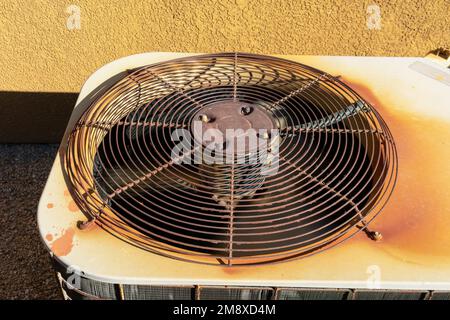 Rusty air conditioning unit machine outside stucco wall red rock Stock Photo