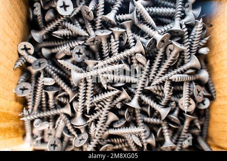 Close-up black metal screws in a cardboard box Stock Photo