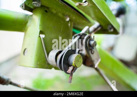 The control lever on a walk-behind tractor close-up on a blurred background. Control elements of agricultural machinery. Stock Photo