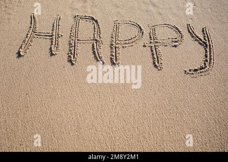 Happy word written on sand. Travel summer beach vacation concept Stock Photo