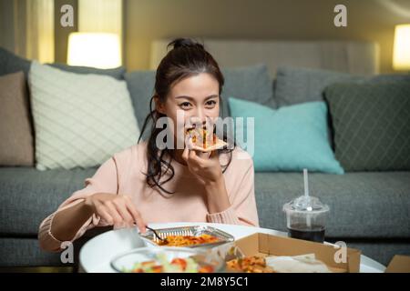 The young lady at home eating take-away Stock Photo