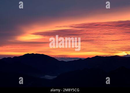 Sunrise in Vall de Lord valley with fog over the reservoir and reddish clouds. Seen from Port del Comte (Solsonès, Lleida, Catalonia, Spain) Stock Photo