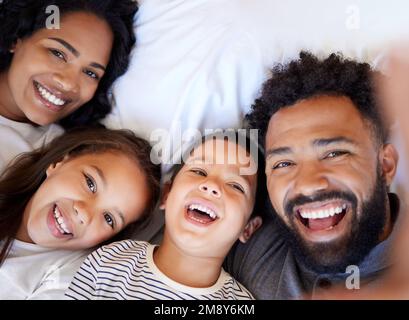 Give me a smile. a young family relaxing together at home. Stock Photo