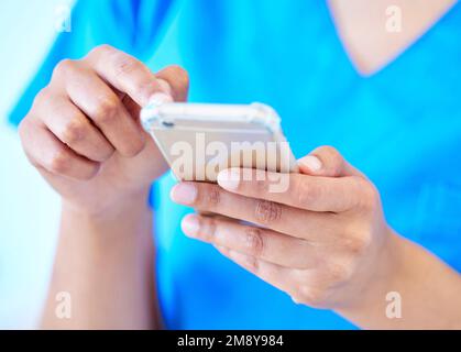 Those fingers move fast. a female dental assistant using her smartphone to send a text. Stock Photo