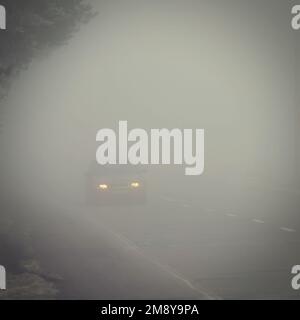 Cars in the fog. Traffic on the road in winter in bad weather. Dangers of driving cars. Stock Photo
