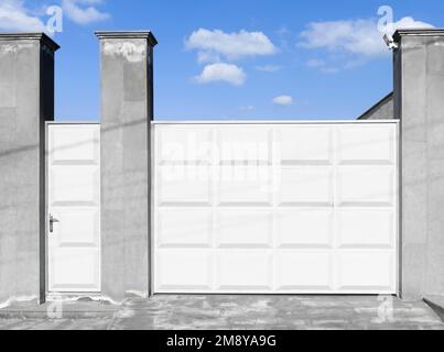 Modern white aluminium sliding gate. Gate portal of suburb door house. Stock Photo