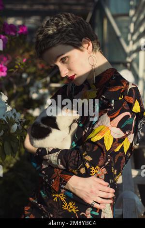 Close up pretty woman holding puppy in home garden portrait picture Stock Photo