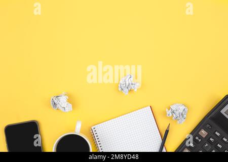 Notepad, calculator, coffee cup and smartphone on yellow background, flat lay. Stock Photo