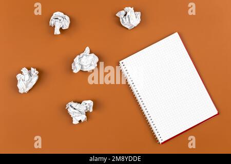 Empty notebook and crumpled paper balls, flat lay. Stock Photo