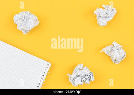 Empty notebook and crumpled paper balls, flat lay. Stock Photo