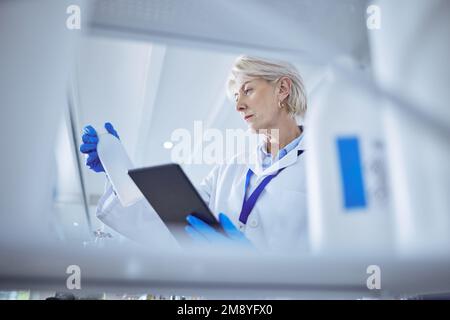 This should help. a mature female scientist working on her digital tablet in the lab. Stock Photo