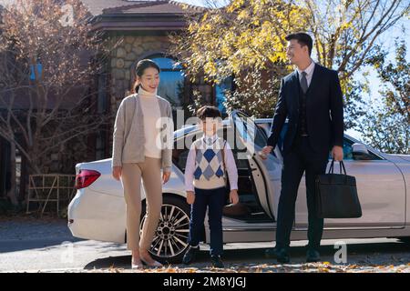 A young couple pick up the kids from school Stock Photo