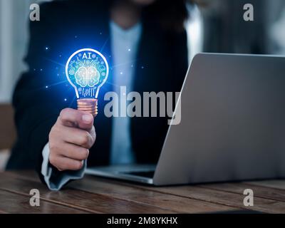 Artificial intelligence technology concept. Glow digital light bulb graphics with AI brain system inside, hold by business people. Creative innovation Stock Photo
