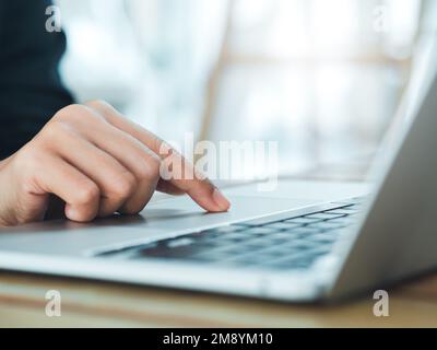 Close-up finger of business person in suit touch on touchpad on laptop computer. Working on notebook, business technology concept. Control your digita Stock Photo