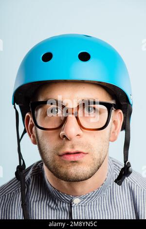 Where did you say we were going. a handsome young man standing alone in the studio and posing while wearing a helmet. Stock Photo