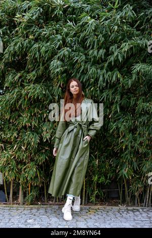 Woman influencer in stylish trendy clothes poses full-length against a backdrop of bamboo trees, lifestyle blogger spring Stock Photo