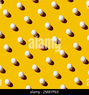 Chicken white eggs pattern on yellow background with one brown egg in the middle. Different concept. Stock Photo