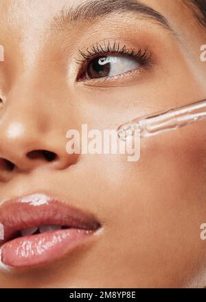 Applying a soothing face serum. an attractive young woman applying serum to her face. Stock Photo