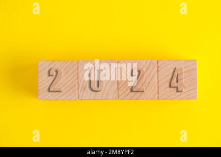 Wooden cubes with numbers 2024 yellow background Stock Photo - Alamy